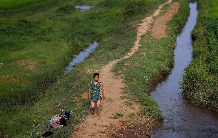 Một bé gái mặc đồ bơi đi bộ gần con suối ở Hamju, Triều Tiên. Bức ảnh chụp ngày 20/7/2017.