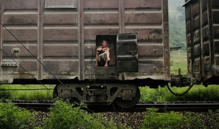 Một người đàn ông ngồi trên toa tàu chở hàng ở ngoại ô Hamhung ngày 21/7/2017.