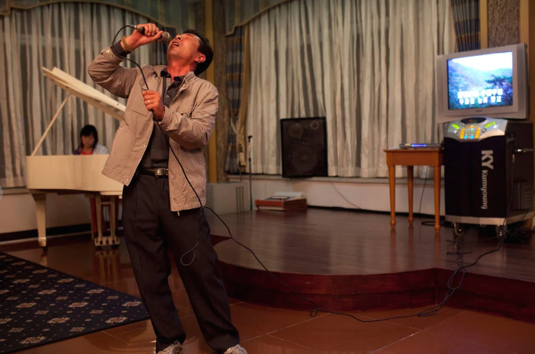 Một người đàn ông hát karaoke trong khi con gái chơi piano trong quán của khách sạn ở núi Kumgang, Triều Tiên, ngày 7/10/2011.