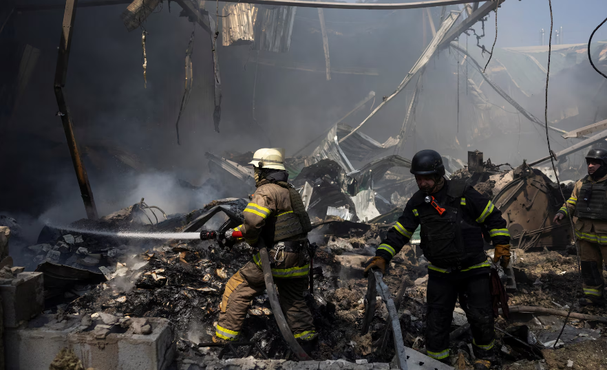 Lính cứu hỏa chữa cháy tại khu nhà in bị phá hủy sau đợt tấn công của Nga.