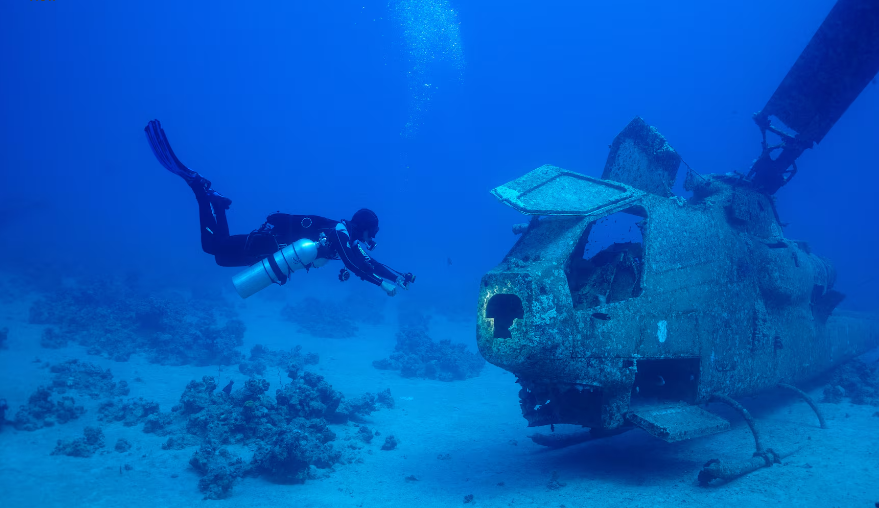 Bảo tàng được khánh thành vào năm 2019 với hy vọng sẽ cải thiện môi trường cho các sinh vật biển, khuyến khích nhiều người đam mê lặn hơn. Ảnh: Một thợ lặn bơi cạnh trực thăng quân sự chìm dưới nước tại bảo tàng quân sự Aqaba ngày 7/5.