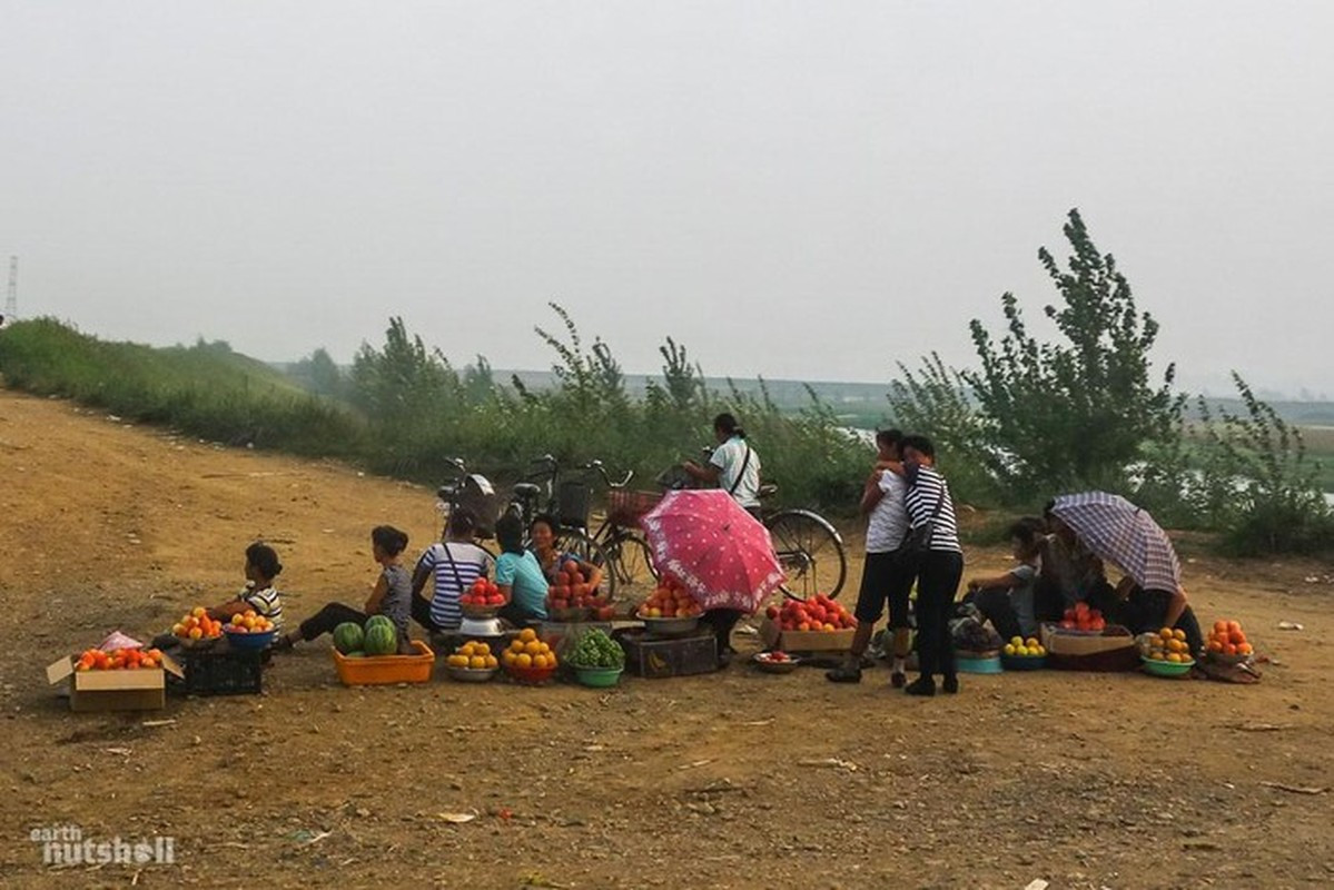 Người dân bán hàng trên một con đường đất ở khu vực nằm giữa Kaeju và Sariwon, Triều Tiên.