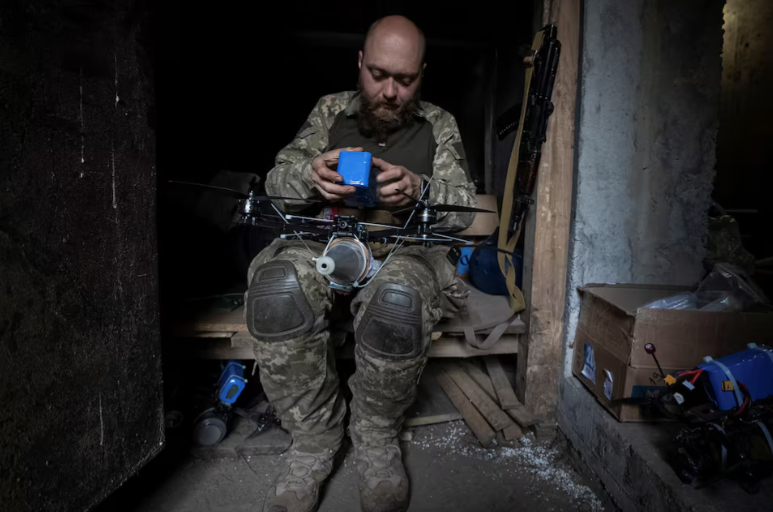 Binh sĩ thuộc tiểu đoàn máy bay không người lái tấn công Achilles, lữ đoàn 92, gắn một quả đạn pháo vào máy bay không người lái góc nhìn thứ nhất (FPV) tại vị trí tiền tuyến ở Vùng Kharkov ngày 15/5.