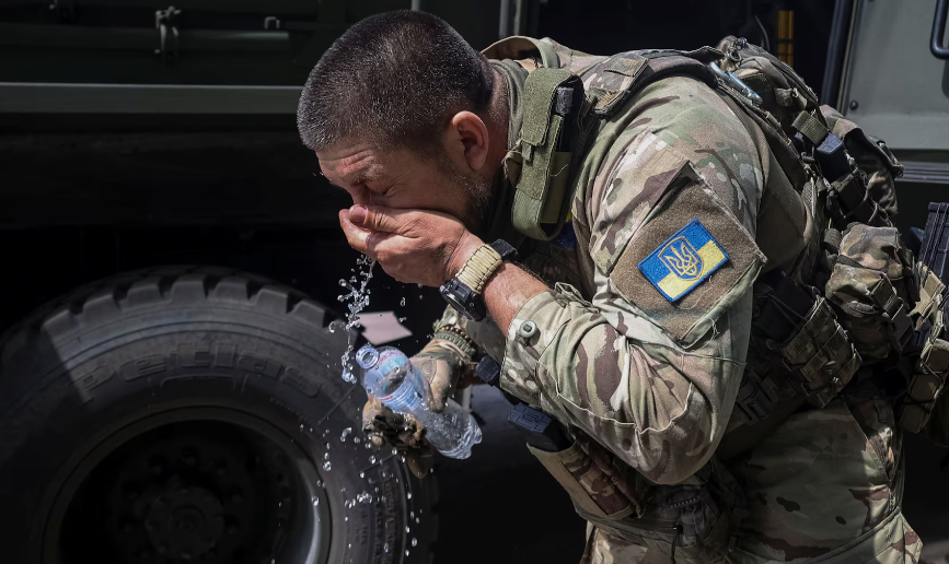 Một quân nhân Ukraine rửa mặt sau khi sơ tán một đồng đội bị thương khỏi tiền tuyến gần thị trấn Vovchansk ngày 12/5.