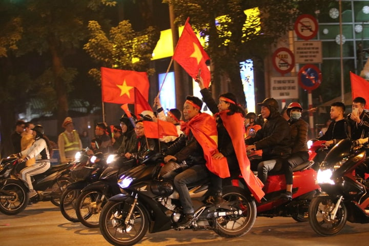 Tuy nhiên, trong dòng người đổ ra đường diễu hành chia vui chiến thắng, có một bộ phận CĐV không đội mũ bảo hiểm. (Ảnh Infonet)