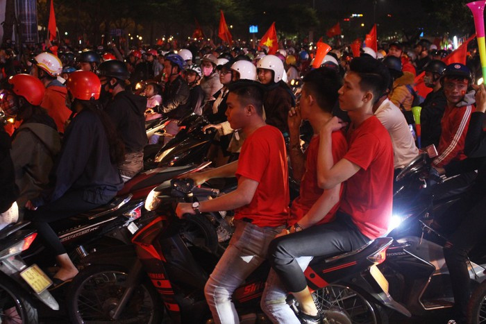 Nhiều CĐV chở ba, chở bốn và không đội mũ bảo hiểm đi cùng đoàn diễu hành. (Ảnh: Tienphong)