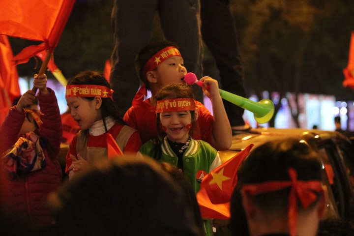 Nhiều cháu bé đã cùng phụ huynh ra đường ho rơ, vẫy cơ, thổi kèn ăn mừng chiến thắng. (Infonet)