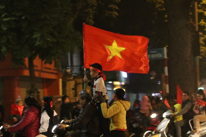 Cổ đông viên nhỉ đi cùng phụ huynh ra đường. (Infonet)