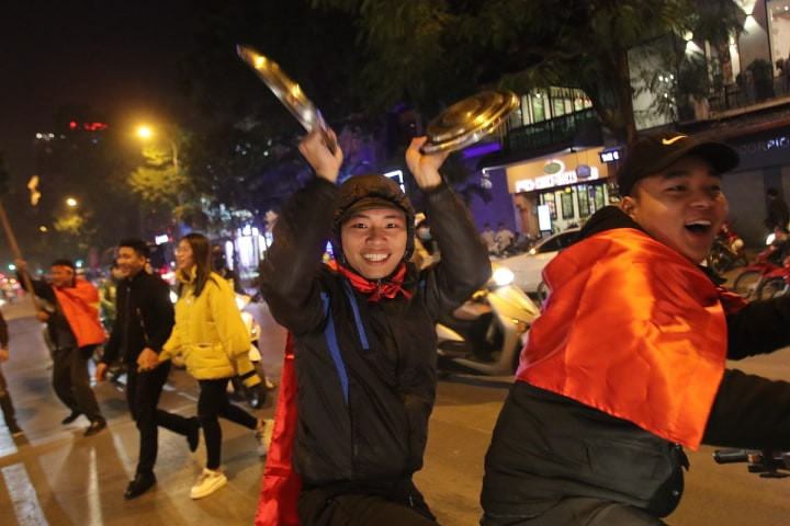 Nam thanh niên gõ nắp nồi để khuấy động trên đường. (Infonet)