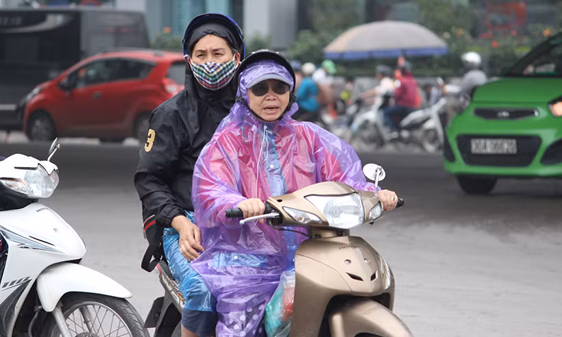 Thời tiết Hà Nội trong sáng nay có mưa rào bất chợt, nên người dân khi di chuyển về bến xe phải mặc áo mưa.