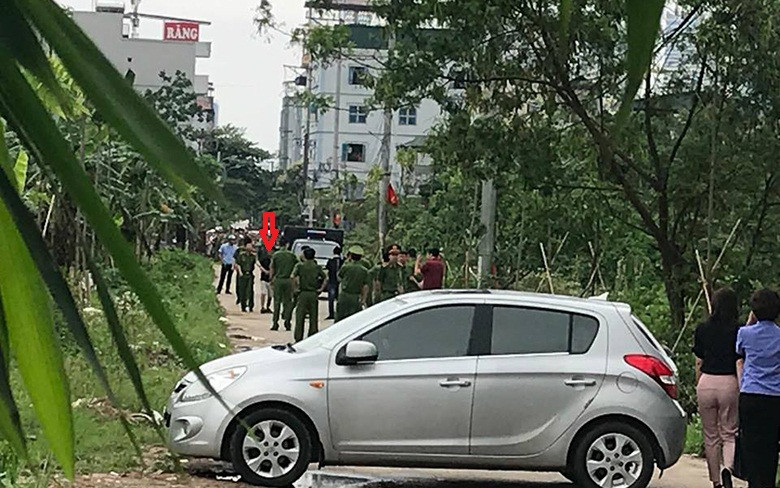 Hàng chục cảnh sát dẫn giải nghi phạm sát hại nam sinh, nhét bao tải Chử Tuấn Sơn (mũi tên đỏ) đến hiện trường ở bãi rác cạnh đường làng Tân Mỹ (Hà Nội).
