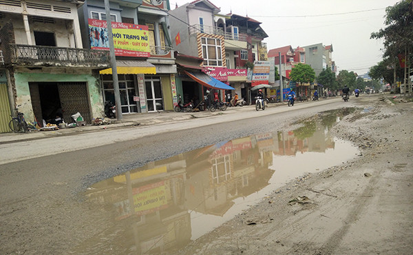 Những đoạn đường sụt lún bị xe quá khổ, quá tải làm hư hỏng mưa xuống nước tù đọng như cái "bẫy" người tham gia giao thông.