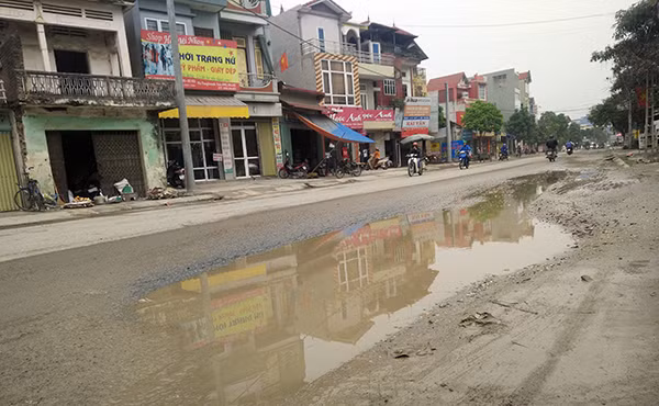 Những đoạn đường sụt lún bị xe quá khổ, quá tải làm hư hỏng mưa xuống nước tù đọng như cái "bẫy" người tham gia giao thông.