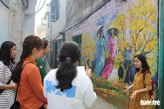 Đặc biệt, khách đến hẻm bích họa sẽ được các tình nguyện viên hướng dẫn, giới thiệu tham quan nếu có nhu cầu. Ảnh: ĐOÀN NHẠN