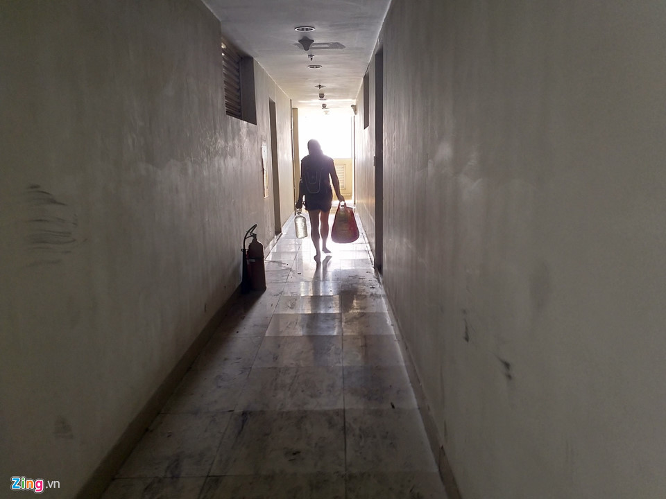 Một người phụ nữ xuất hiện tại lầu 9 tòa nhà. Chị cho biết trở về để tưới cây. Hiện gia đình chị được chủ đầu tư hỗ trợ sống tại tòa chung cư đối diện. "Vài ngày lại về kiểm tra cửa nẻo, đồ đạc. Giờ làm gì còn ai trông coi tòa nhà đâu. Trống không rồi", cư dân này nói vội trước khi rảo bước.