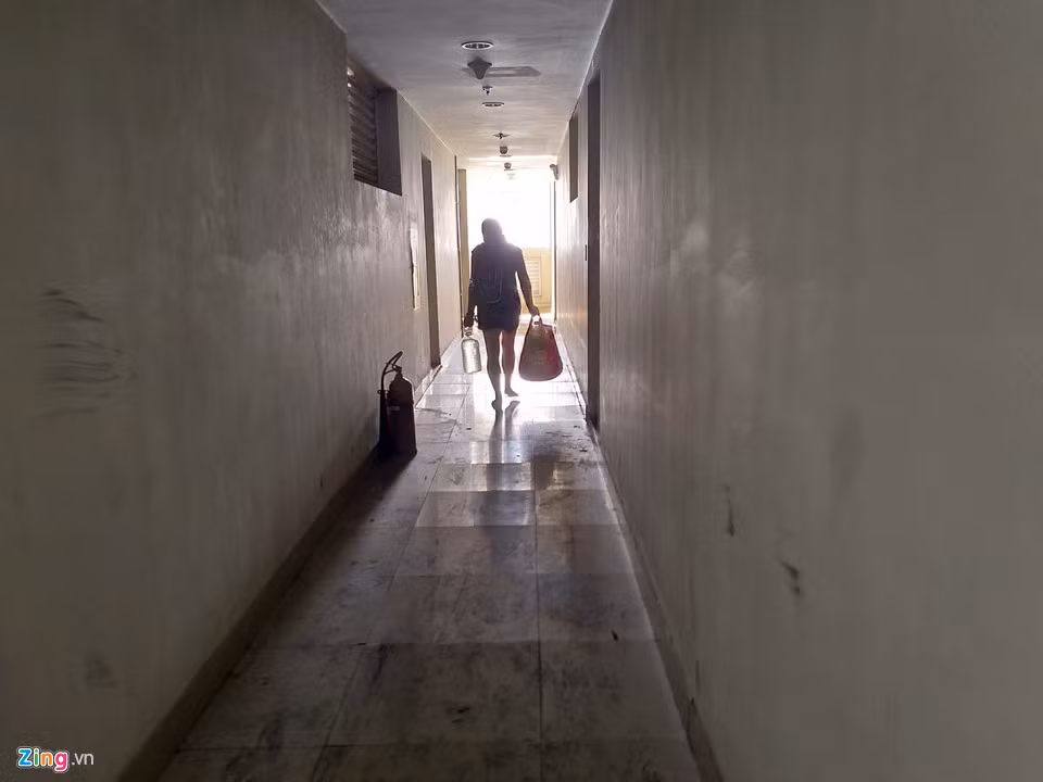 Một người phụ nữ xuất hiện tại lầu 9 tòa nhà. Chị cho biết trở về để tưới cây. Hiện gia đình chị được chủ đầu tư hỗ trợ sống tại tòa chung cư đối diện. "Vài ngày lại về kiểm tra cửa nẻo, đồ đạc. Giờ làm gì còn ai trông coi tòa nhà đâu. Trống không rồi", cư dân này nói vội trước khi rảo bước.