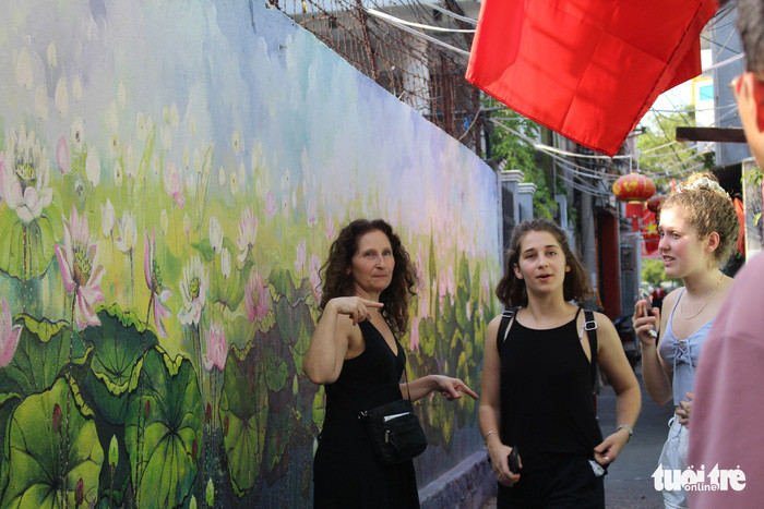 Nhiều khách du lịch nước ngoài thích thú với hẻm bích họa - Ảnh: ĐOÀN NHẠN