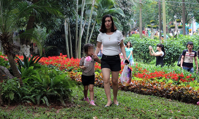 Nhiều phụ huynh thản nhiên dắt con em mình đạp lên cỏ, trong khi nhiều người khác chấp hành rất tốt theo quy định.