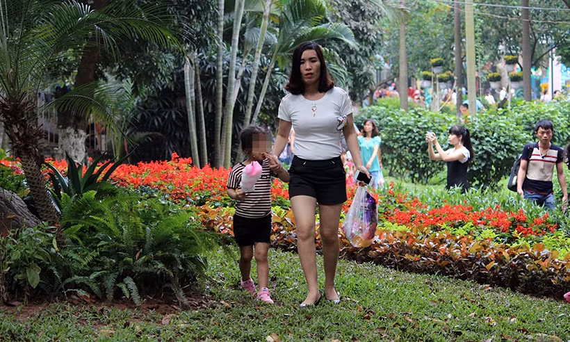 Nhiều phụ huynh thản nhiên dắt con em mình đạp lên cỏ, trong khi nhiều người khác chấp hành rất tốt theo quy định.