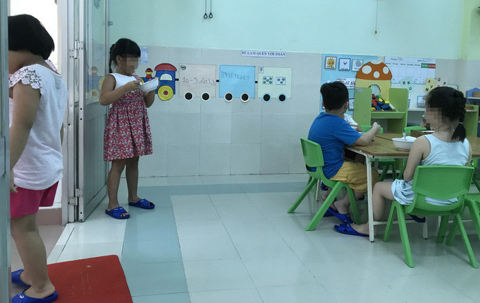 Một bé lớp Lá 1 bị cô giáo phạt đứng ăn cơm - Ảnh: Giáo viên và phụ huynh cung cấp.