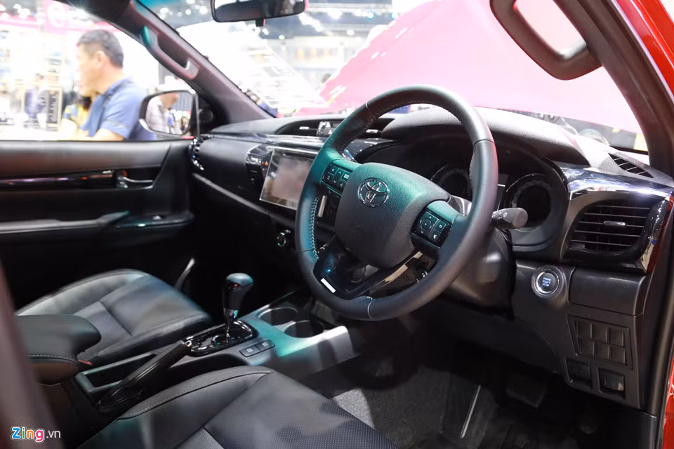 Bên trong nội thất Hilux 2018 hầu như không thay đổi so với đời trước. Vẫn còn đó bảng đồng hồ Optitron quen thuộc nằm phía sau vô-lăng đa chức năng, tích hợp cần gạt điều chỉnh hệ thống ga tự động cruise control, nút bấm khởi động máy kết hợp cùng chìa khóa thông minh, nút chuyển chế độ vận hành Eco/Power, ngăn làm mát và cửa gió điều hòa cho hàng ghế sau.