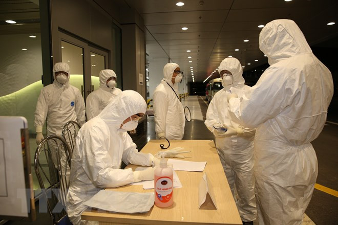 Nhân viên Cảng hàng không sân bay Vân Đồn làm thủ tục nhập cảnh cho các công dân. (Ảnh: TTXVN)