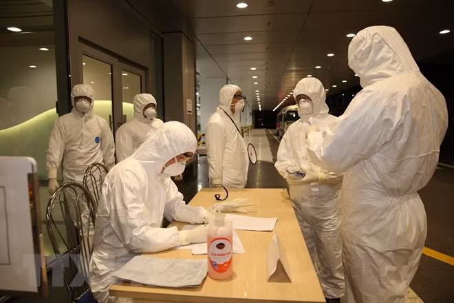 Nhân viên Cảng hàng không sân bay Vân Đồn làm thủ tục nhập cảnh cho các công dân. (Ảnh: TTXVN)