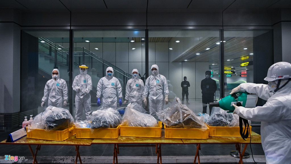 Hình ảnh cơ quan chức năng kiểm tra sàng lọc để phát hiện các trường hợp nghi ngờ qua máy đo thân nhiệt từ xa, phun khử trùng hành lý xách tay của hành khách. (Ảnh: Zing)