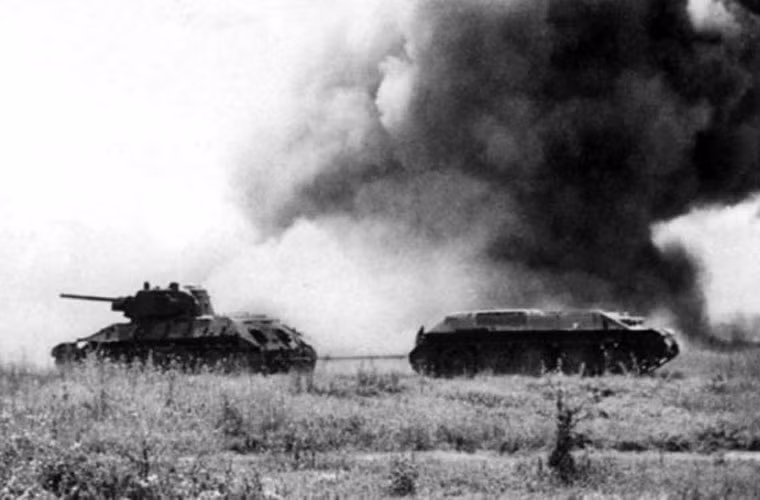 Một chiếc T-34-76 đang kéo theo thân xe tăng T-34 khác bị mất tháp pháo trong trận chiến tàn khốc.