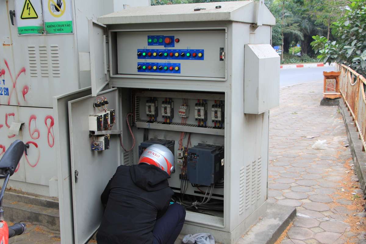 Nhóm công nhân cũng tranh thủ kiểm tra hệ thống điện của trạm bơm trước khi tìm đến một đống lửa để sưởi ấm sau nhiều tiếng móc rác dưới dòng sông Tô Lịch