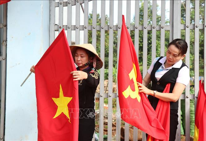 Người dân và cán bộ xã Cư Mgar cùng nhau thực hiện “đường cờ” chào mừng Đại hội lần thứ XIII của Đảng.