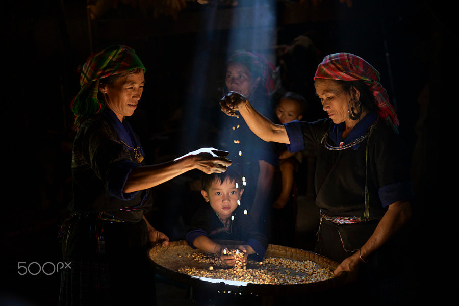 Phụ nữ và trẻ em H'Mông với chiếc nong đựng hạt ngô tại một bản ở Mù Căng Chải.