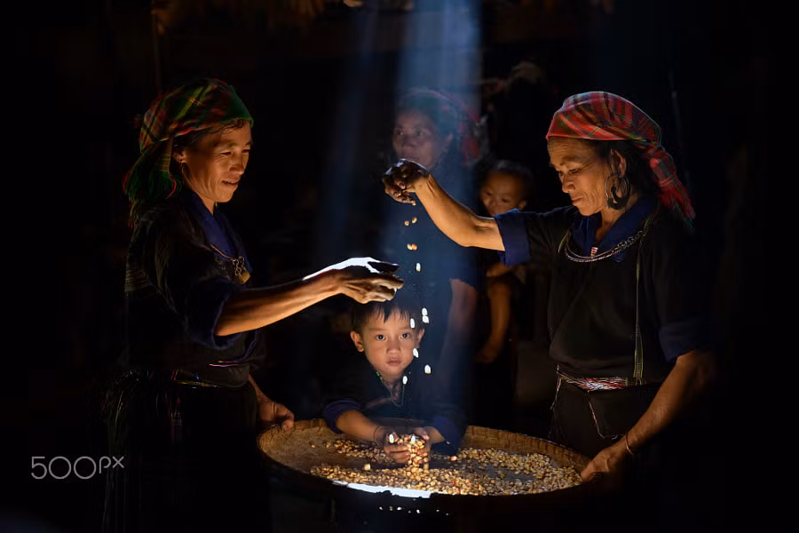 Phụ nữ và trẻ em H'Mông với chiếc nong đựng hạt ngô tại một bản ở Mù Căng Chải.