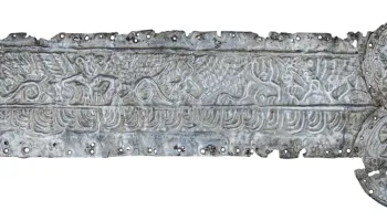 Mặt trái của đồ vật được trang trí các sinh vật hoang dã đang đứng với tư thế đặc biệt, gắn với 2 khóa tròn mô tả một người đội vương miện và nhiều hình ảnh trang trí tinh xảo khác.