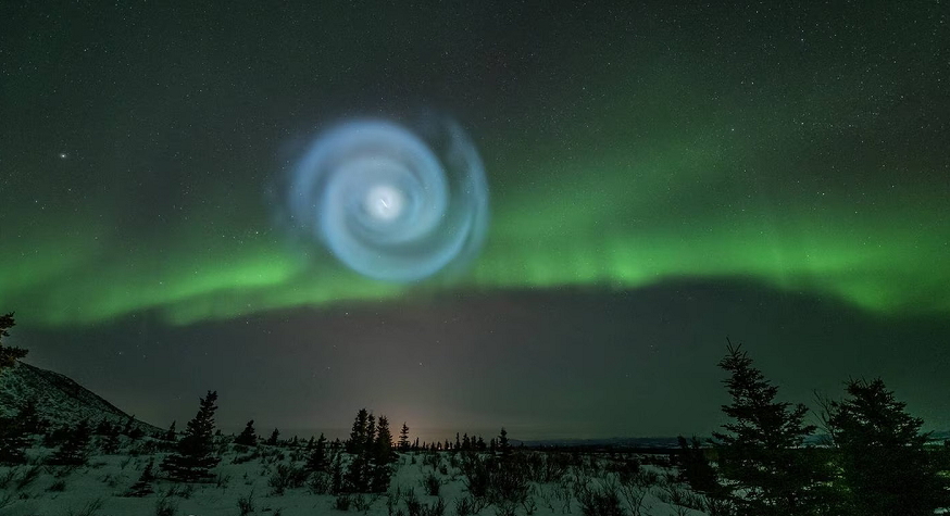 Theo các chuyên gia, hiện tượng hình xoắn ốc màu xanh nhạt trên bầu trời Alaska có thể được giải thích qua hiệu ứng cực quang.
