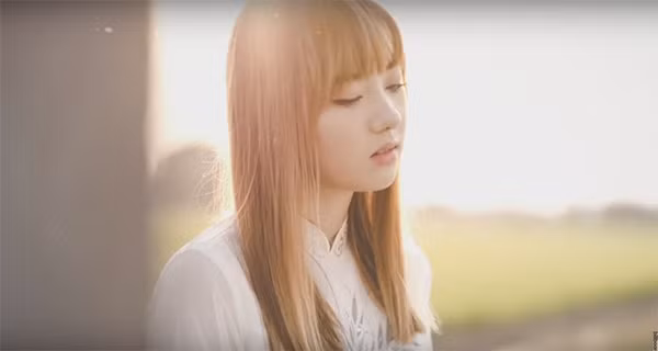 Jannine diện áo dài màu trắng, đầu đội nón lá, tóc xõa ngang vai. Nụ cười trong sáng cùng vóc dáng mảnh mai của thiếu nữ 10X càng được chiếc áo dài tôn vinh.