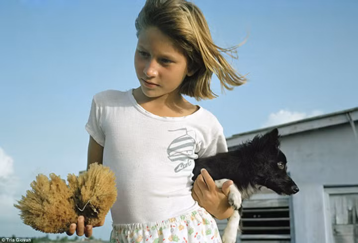 Bé gái ôm chú chó cưng ở thị trấn ven biển Caibarien hay còn được gọi là 'La Villa Blanca'. Bức ảnh được Giovan chụp năm 1992.