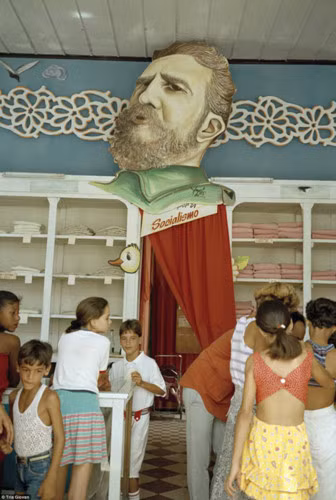 Hình ảnh lãnh tụ Fidel Castro được treo trước cửa một cửa hàng quần áo trẻ em ở Remedios, gần Caibarien.