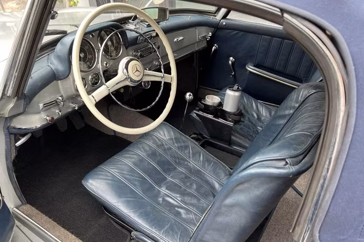 Chiếc Mercedes-Benz 190 SL hàng hiếm của Qua Vũ sở hữu “bộ cánh” màu bạc, đi kèm các chi tiết mạ chorme mang lại cảm giác sang trọng. Ở hai bên cánh cửa, xe được dán đề can chữ “UN” màu đen – đây là chi tiết xuất hiện trên hầu hết các mẫu xe của đại gia ngành cà phê.