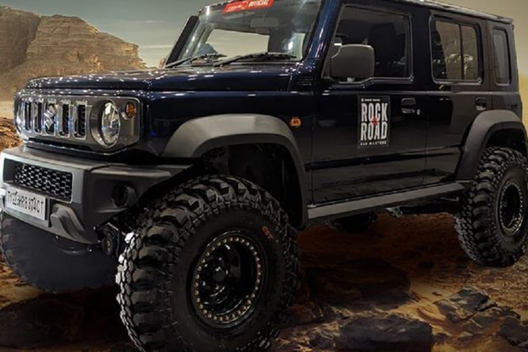 Diện mạo của chiếc Suzuki Jimny 5 cửa trở nên hầm hố hơn hẳn nhờ được trang bị bộ lốp gai 15 inch, đi kèm mâm xe độc đáo được hoàn thiện bằng đinh tán. Để phù hợp với những chiếc lốp như vậy, hệ thống treo đã được nâng lên đáng kể, khiến khoảng sáng gầm tăng lên 30 cm (nguyên bản 21 cm).