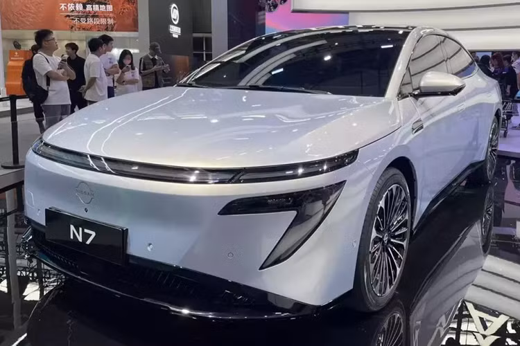 Khu vực đầu xe của Nissan N7 2025 chạy điện được thiết kế gọn gàng và hiện đại với dải đèn LED định vị ban ngày vắt ngang, gợi liên tưởng đến ô tô Hyundai. Bên dưới là cụm đèn pha LED hình số "7" và hốc gió trung tâm được bao quanh bằng viền màu đen bóng.