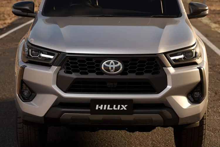 Đầu xe Toyota Hilux 2024 mới gây ấn tượng với lưới tản nhiệt hình bát giác mới đi kèm các khe hút gió hình tổ ong và cản trước thể thao hơn. Xe có ốp gầm màu bạc bên dưới giúp chiếc bán tải nhìn mạnh mẽ và hiện đại hơn.