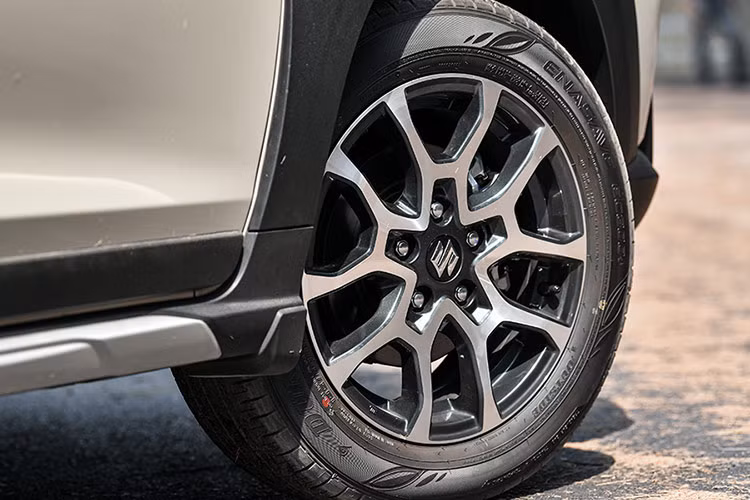 So với phiên bản cũ, Suzuki XL7 Hybrid 2024 chỉ thay đổi nhẹ ở một số chi tiết ngoại thất như lưới tản nhiệt và vành hợp kim 16 inch đều sơn màu đen, nẹp mạ crôm phía dưới kính sau hay logo "Hybrid" ở cửa cốp...