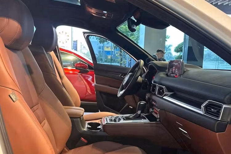 Đồng thời nội thất ấn tượng hơn với chất liệu da Nappa màu nâu đỏ Chroma Brown. Trang bị tiện nghi Mazda CX-8 2025 vẫn bao gồm màn hình giải trí cảm ứng 8 inch hỗ trợ Apple CarPlay và Android Auto không dây, hệ thống âm thanh 10 loa Bose, điều hòa tự động 3 vùng độc lập, hiển thị kính lái HUD, cửa sổ trời, rèm che nắng, sưởi ghế…