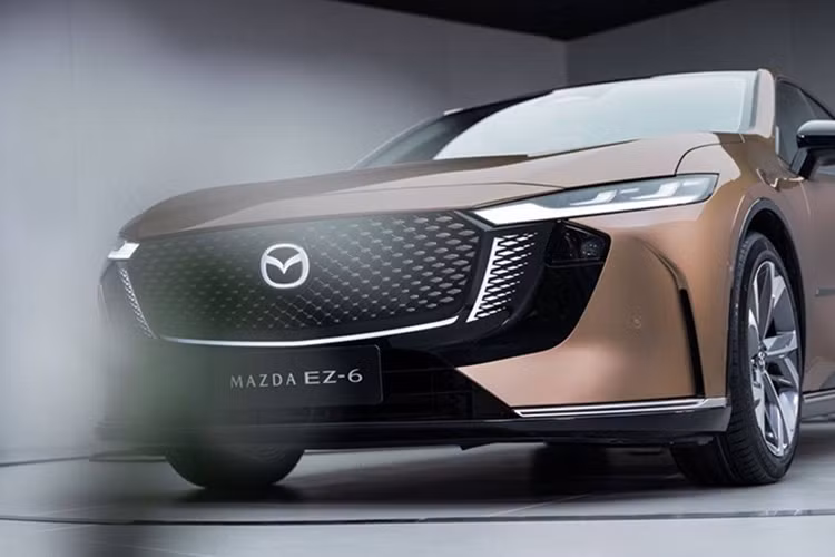 Mazda EZ-6 sở hữu không gian nội thất hiện đại, mang hơi hướng tối giản với hầu hết các nút điều khiển được tích hợp vào màn hình cảm ứng kích thước 14,6 inch đặt giữa mặt taplo. Trong khi đó, vô-lăng và bảng đồng hồ kỹ thuật số 10,2 inch có vẻ giống thiết kế trên mẫu Deepal SL03.