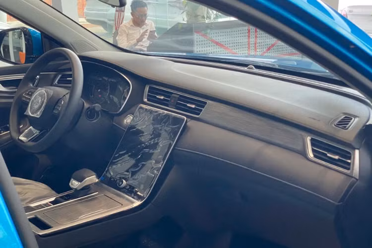 Về nội thất, bên trong khoang cabin của MG RX5 nổi bật với cấu hình 5 chỗ hiện đại. Bản STD tiêu chuẩn sẽ được trang bị ghế nỉ, vô lăng 3 chấu, đằng sau vô lăng là bảng đồng hồ kỹ thuật số 12,3 inch; màn hình cảm ứng trung tâm 14,1 inch của xe được đặt nằm dọc, nối liền với cụm điều khiển trung tâm.