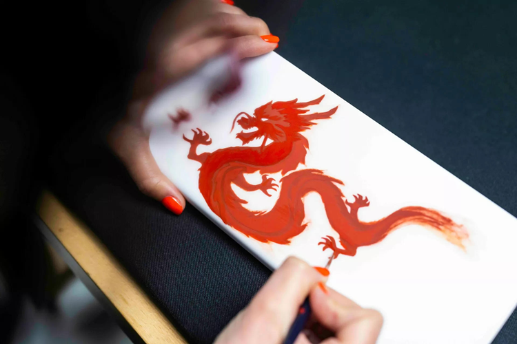 Tên của 12 con giáp được khắc theo kiểu chữ thư pháp, với hình ảnh con rồng được sơn vàng nổi bật. Chiếc thứ tư mang phong cách giản dị hơn lớp veneer màu đen piano và chỉ có một hình khảm rồng bằng thép không gỉ.