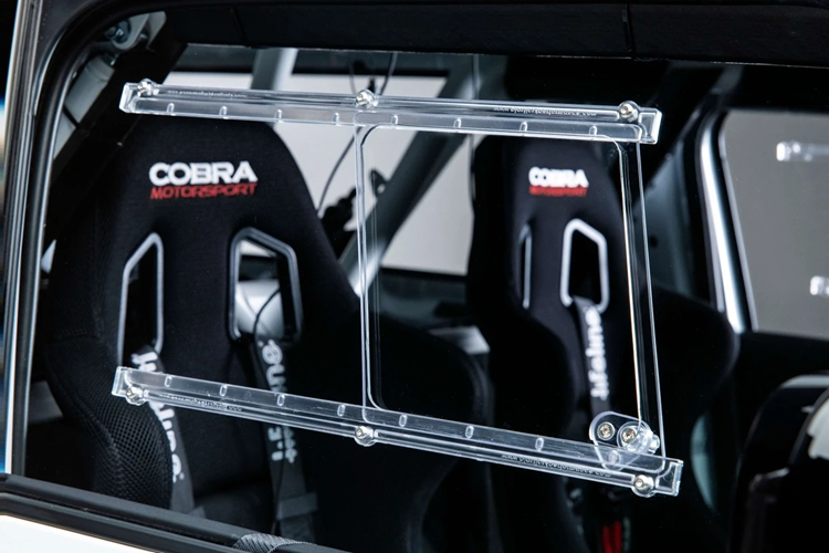 Tương tự các mẫu xe đua chuyên nghiệp, kính cửa sổ và kính chắn gió sau được làm từ chất liệu polycarbonate, giúp giảm khối lượng và bảo vệ người ngồi bên trong khi có sự cố.