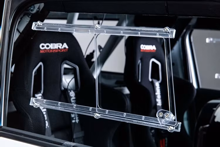 Tương tự các mẫu xe đua chuyên nghiệp, kính cửa sổ và kính chắn gió sau được làm từ chất liệu polycarbonate, giúp giảm khối lượng và bảo vệ người ngồi bên trong khi có sự cố.