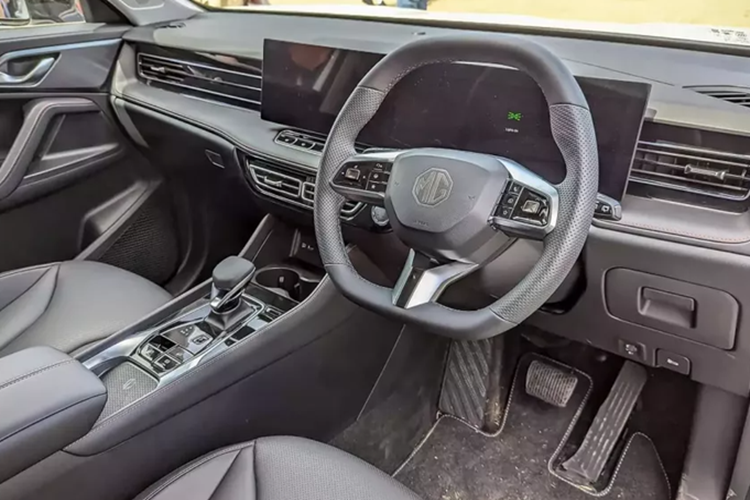 Sâu xuống phía dưới là đèn phản quang 3 tầng, 2 đầu ống xả giả mạ crôm và bộ khuếch tán gió dưới cản sau. Ở bên trong, MG HS 2025 được trang bị 2 màn hình 12,3 inch nối liền với nhau trên mặt táp-lô và cần số mới ở cụm điều khiển trung tâm.